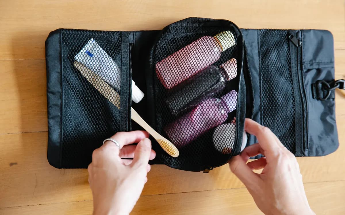 An open travel pouch holding toiletries and a toothbrush.
