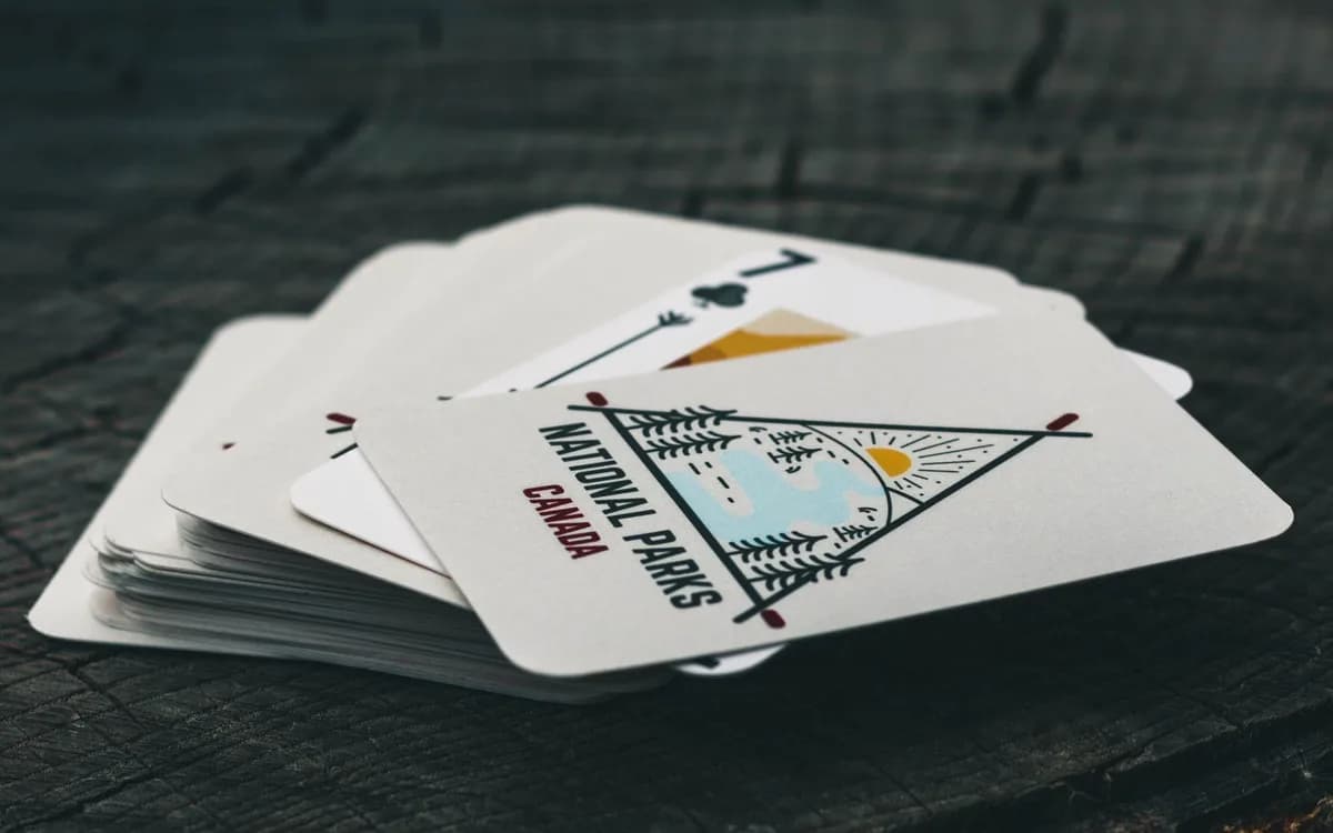 A compact illustrated deck of playing cards resting on a wooden table.