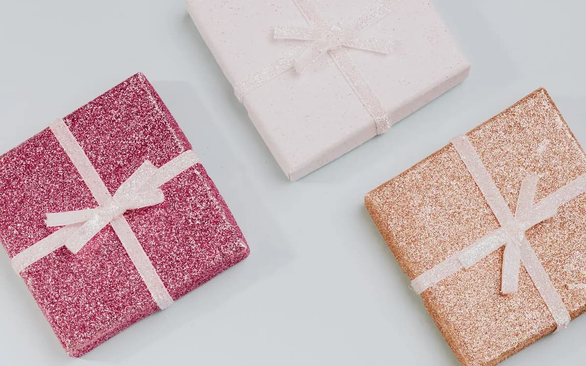 Three small wrapped gifts with ribbons for a birthday countdown.