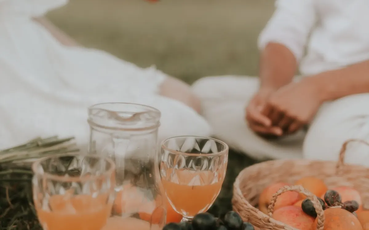 A couple enjoying a picnic together in a green park.