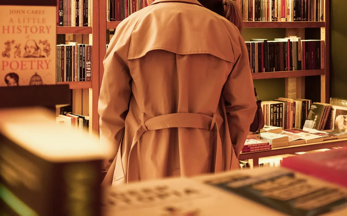 Two people browsing shelves in a cosy bookstore.