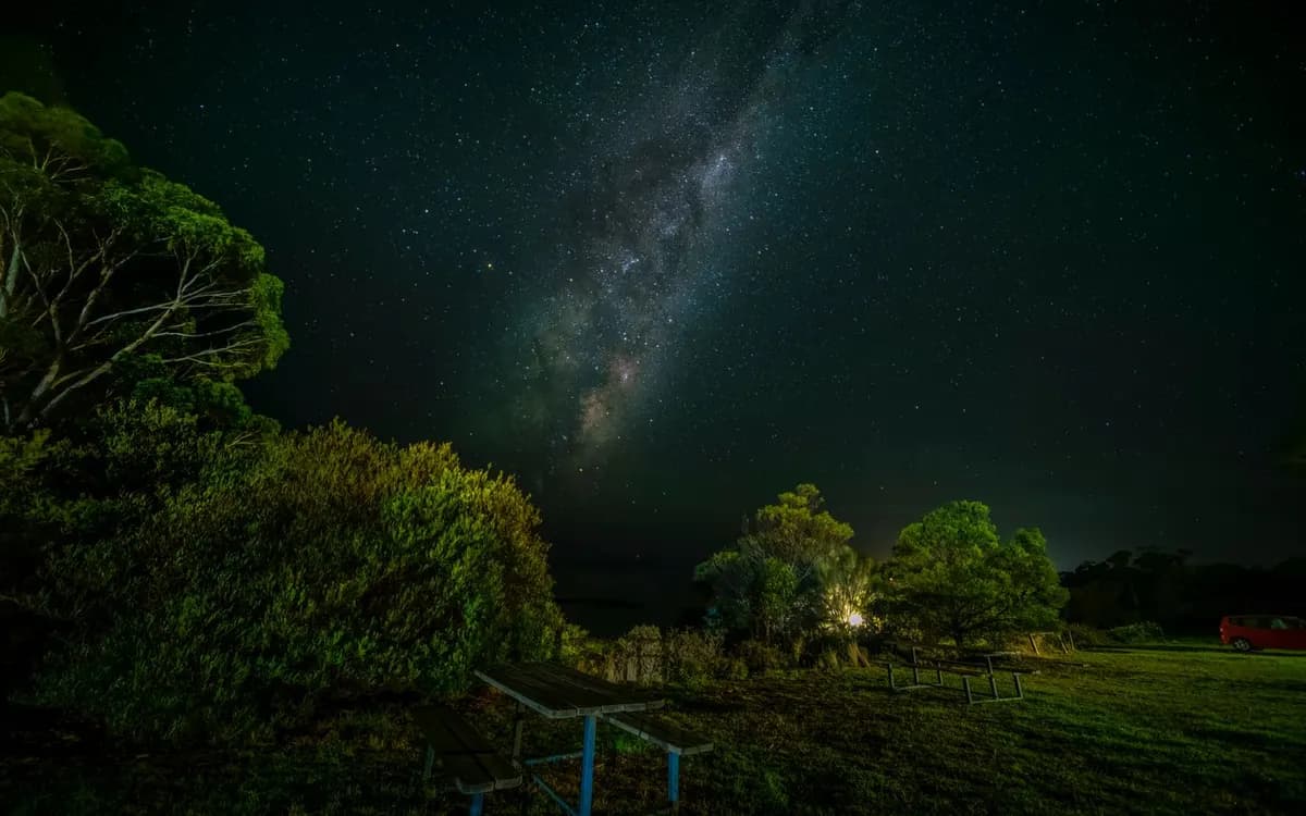 The Milky Way above a quiet picnic area at night.