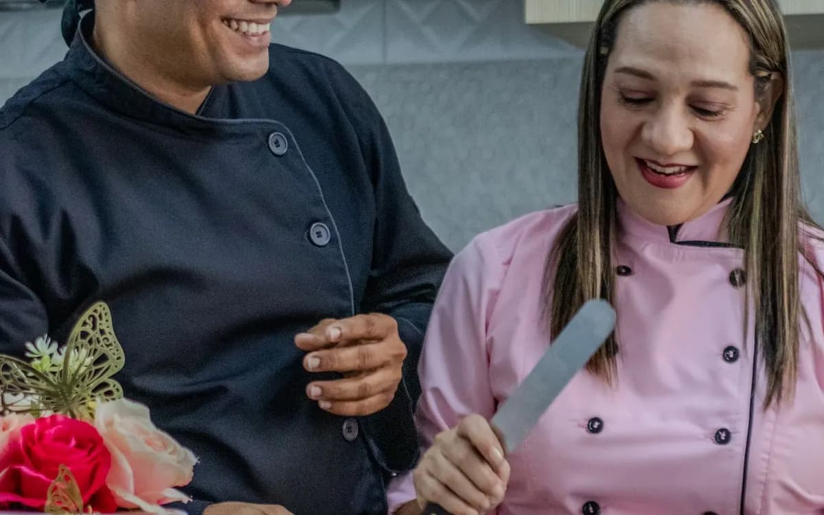 A couple baking cakes together at a kitchen counter.