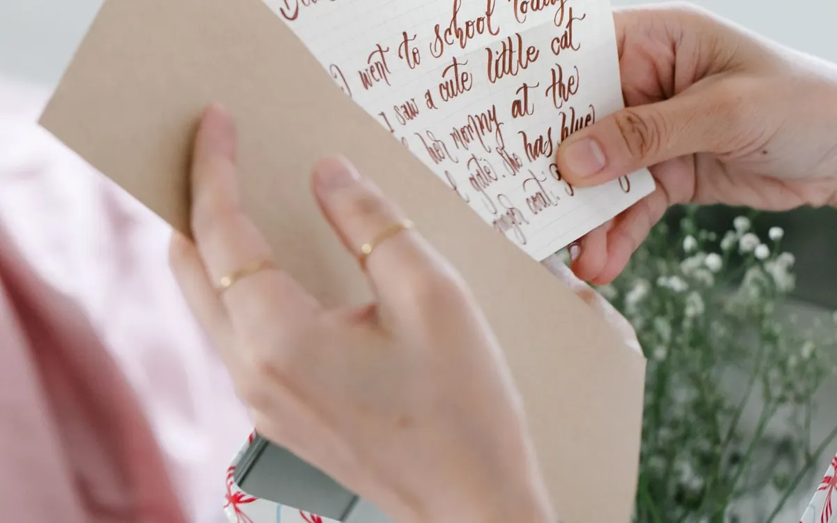 A handwritten letter being taken from an envelope.