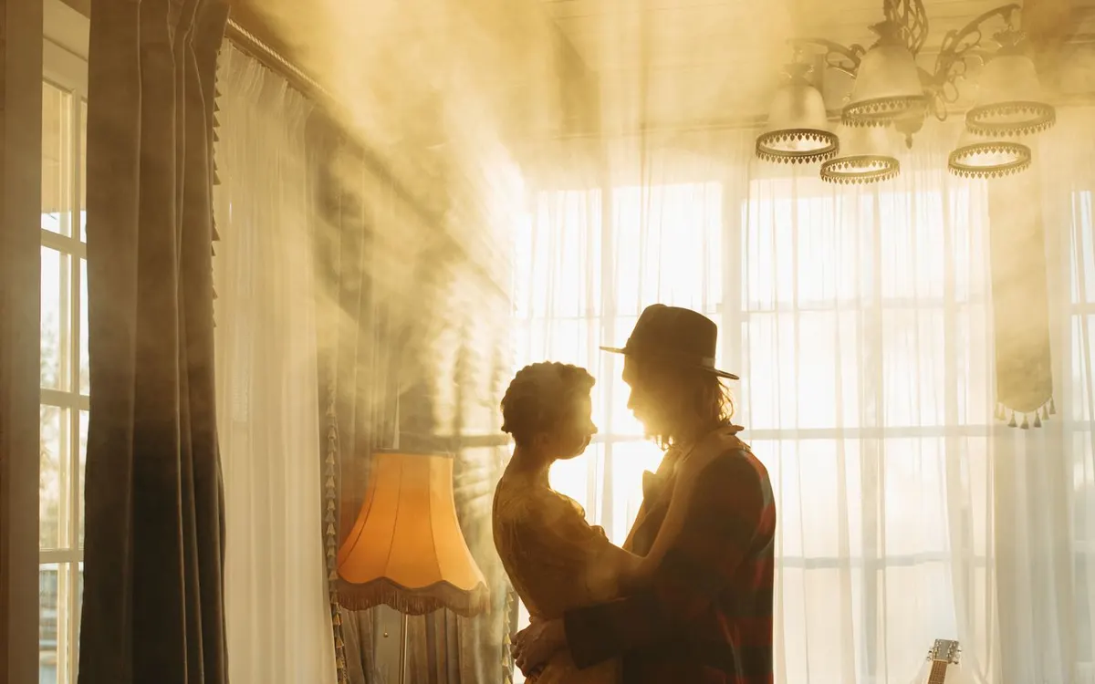 A couple dancing together in a sunlit living room.